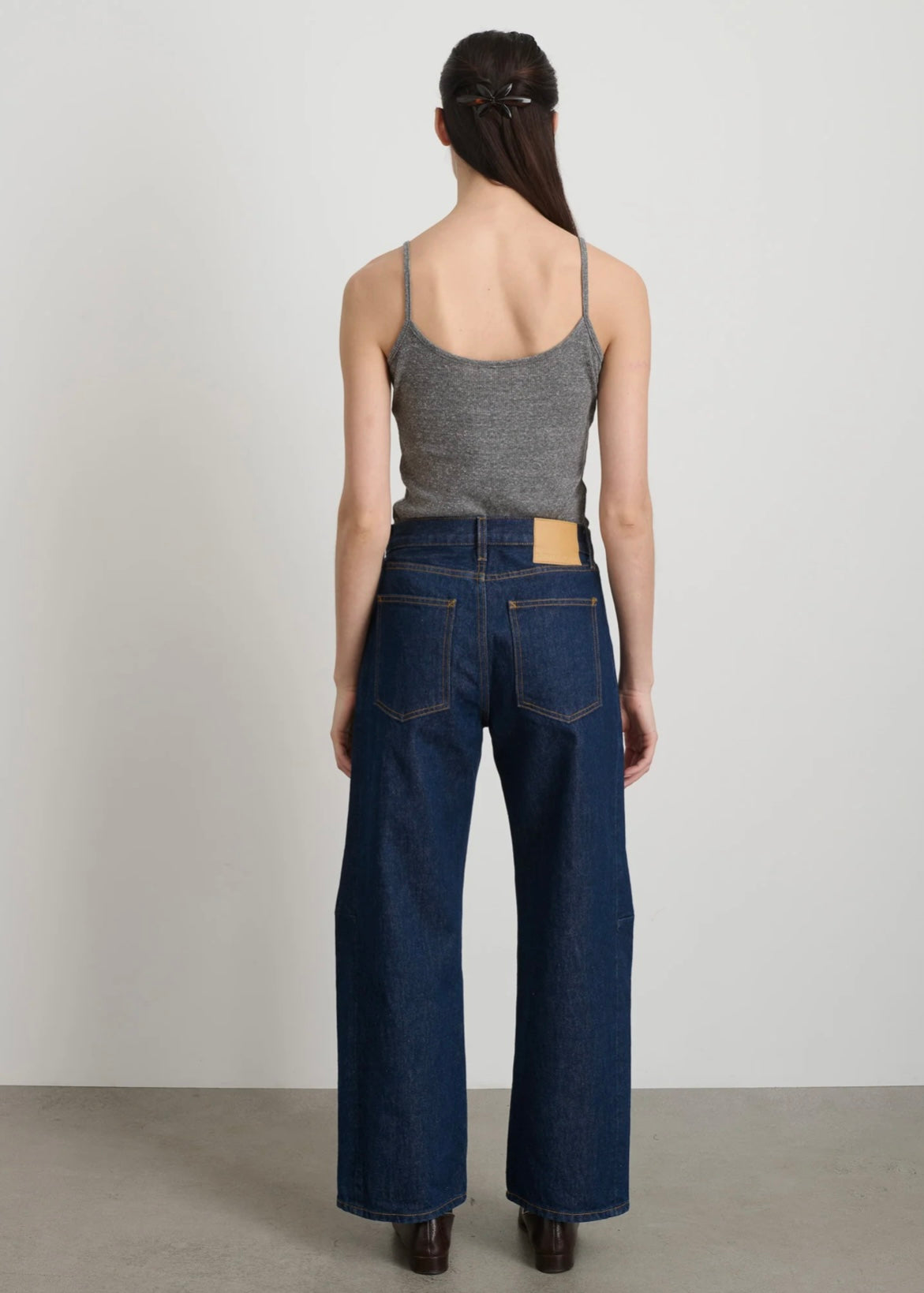 Model is wearing B Sides Lasso Jeans in double-faced Japanese denim, natural waist, kinked leg, cropped length, roped hem, with signature outseam detailing, part of House of Woven Stories curated collection.
