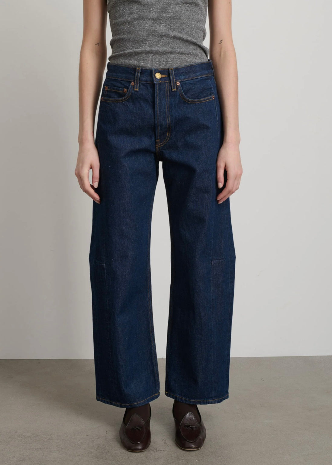 Model is wearing B Sides Lasso Jeans in double-faced Japanese denim, natural waist, kinked leg, cropped length, roped hem, with signature outseam detailing, part of House of Woven Stories curated collection.