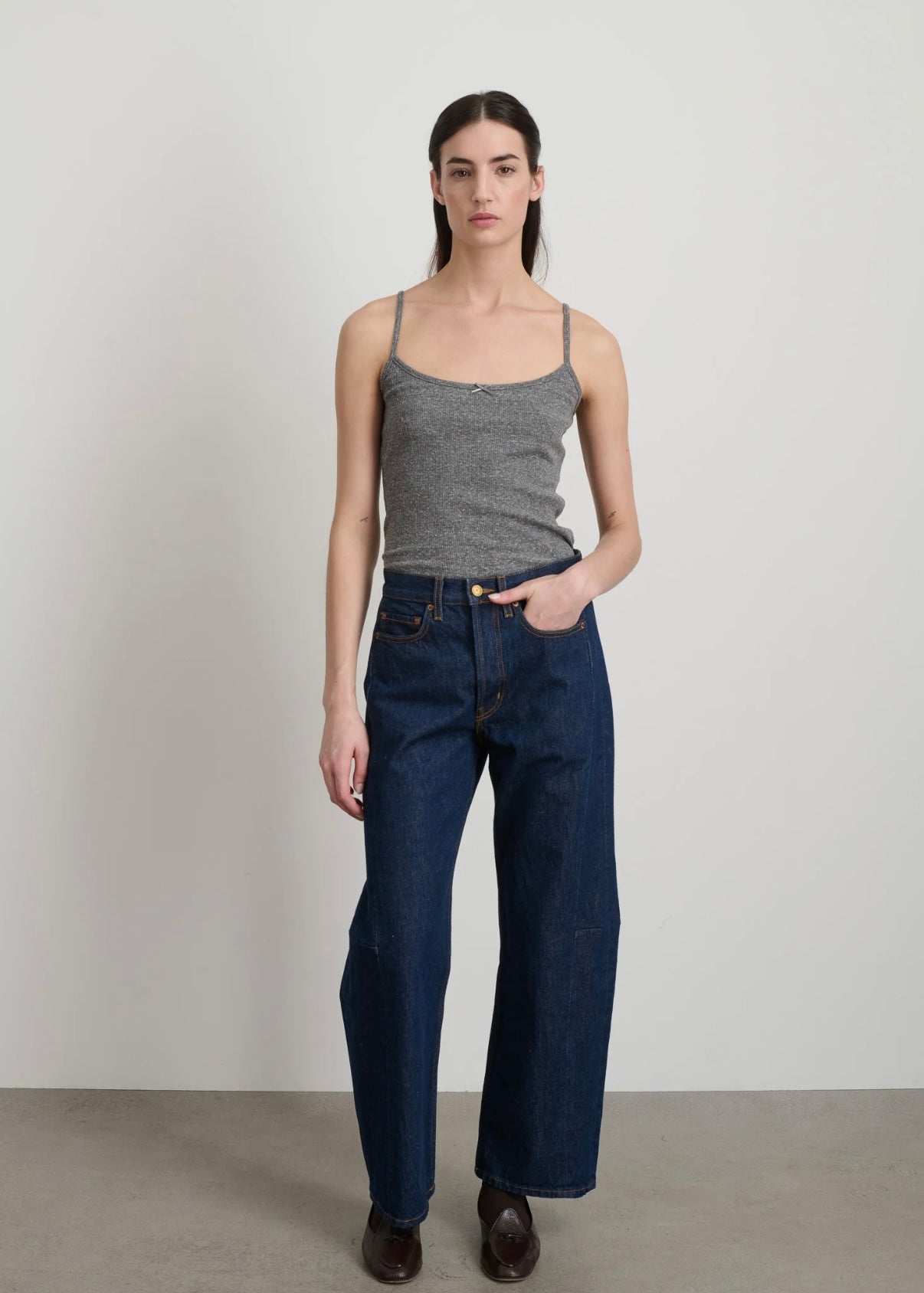 Model is wearing B Sides Lasso Jeans in double-faced Japanese denim, natural waist, kinked leg, cropped length, roped hem, with signature outseam detailing, part of House of Woven Stories curated collection.