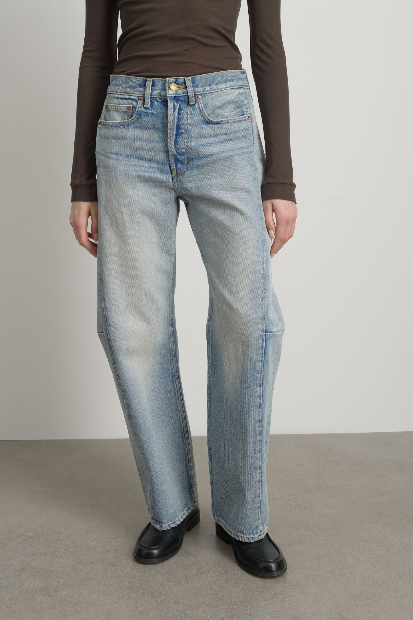 Model is wearing Slim Lasso Cotton Jean Art Wash by B Sides in heavy indigo cotton denim with high waist, pieced outseam, kinked leg and roped hem, available at House of Nomad Stories.