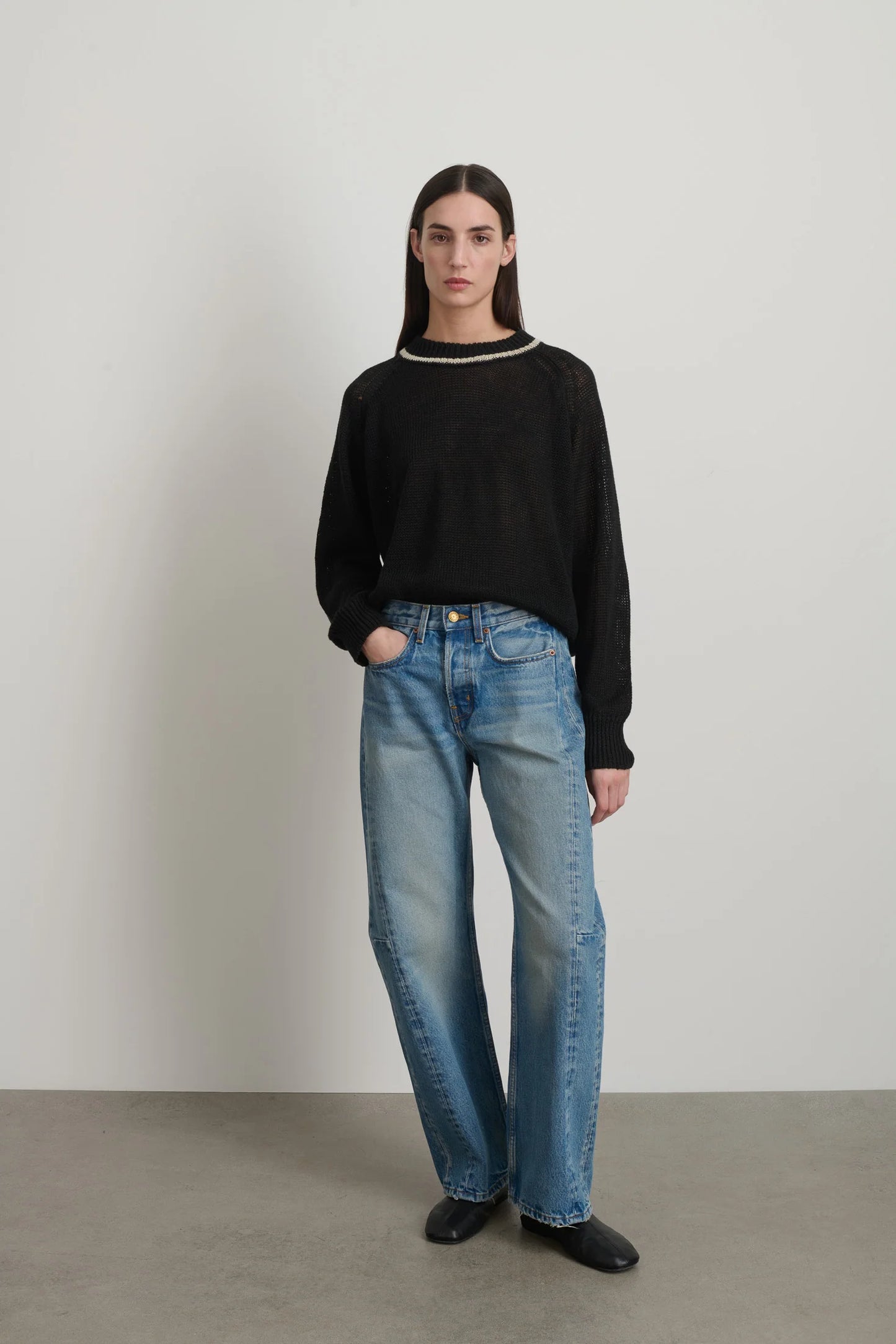 Model is wearing B Sides Slim Lasso Jean in vintage indigo denim, high-rise relaxed kinked leg jeans with 29-inch inseam, stone-washed mid-tone finish, from the curated selection of House of Woven Stories