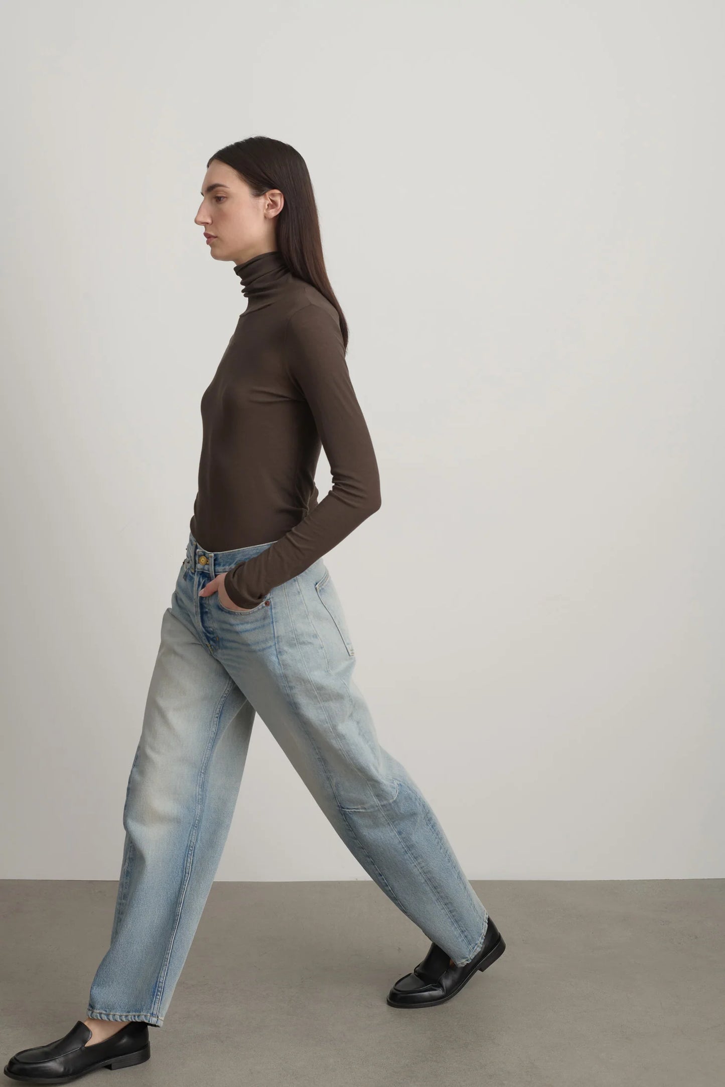 Model is wearing Slim Lasso Cotton Jean Art Wash by B Sides in heavy indigo cotton denim with high waist, pieced outseam, kinked leg and roped hem, available at House of Nomad Stories.