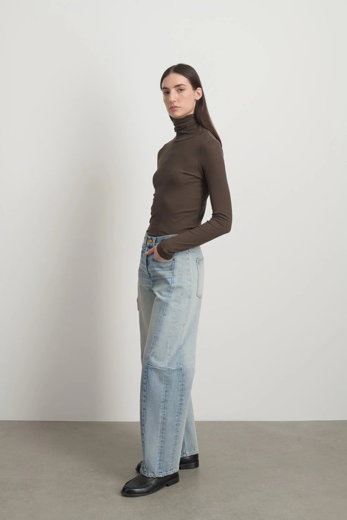 Model is wearing Slim Lasso Cotton Jean Art Wash by B Sides in heavy indigo cotton denim with high waist, pieced outseam, kinked leg and roped hem, available at House of Nomad Stories.