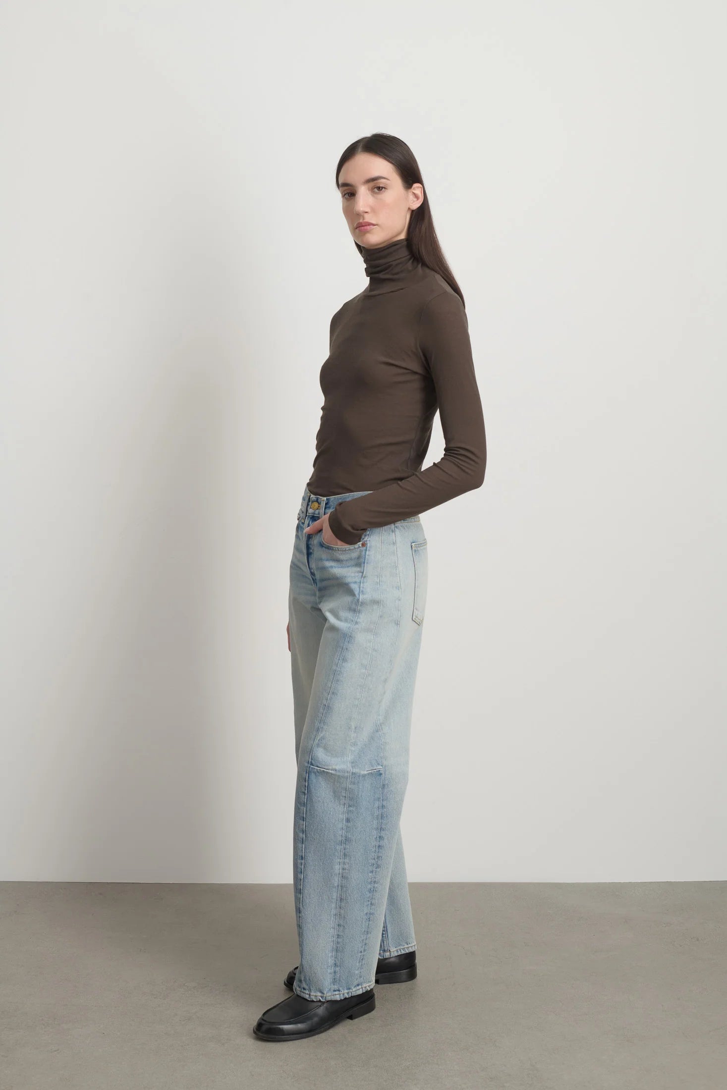 Model is wearing Slim Lasso Cotton Jean Art Wash by B Sides in heavy indigo cotton denim with high waist, pieced outseam, kinked leg and roped hem, available at House of Nomad Stories.