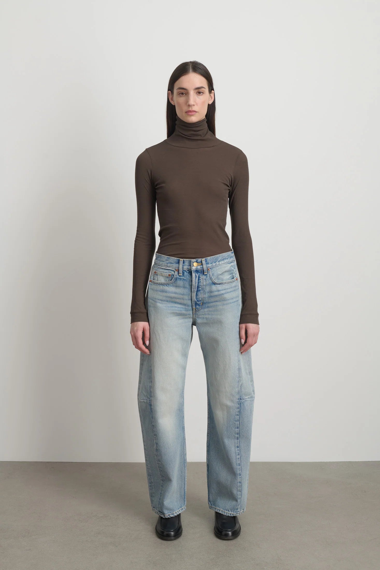 Model is wearing Slim Lasso Cotton Jean Art Wash by B Sides in heavy indigo cotton denim with high waist, pieced outseam, kinked leg and roped hem, available at House of Nomad Stories.