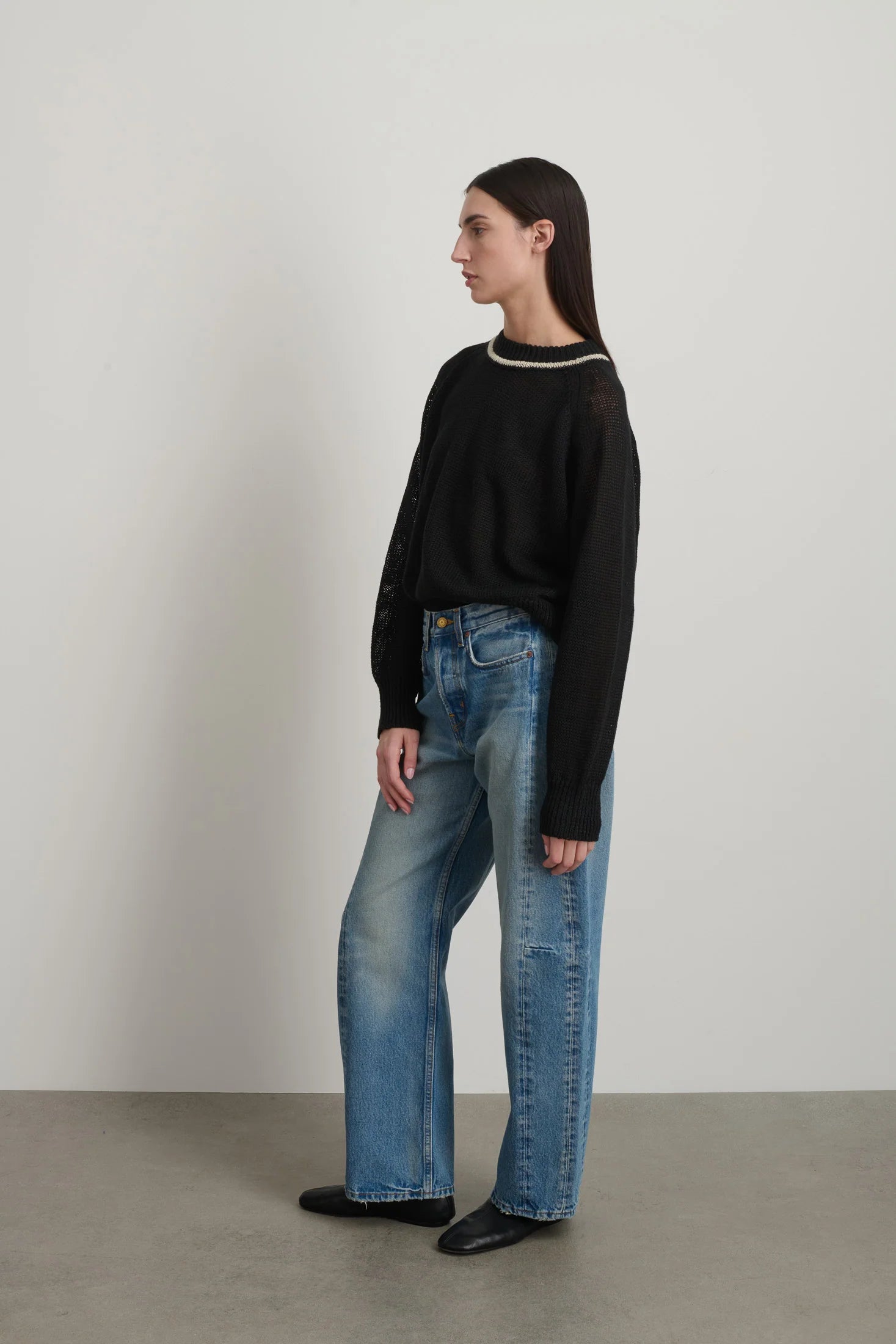 Model is wearing B Sides Slim Lasso Jean in vintage indigo denim, high-rise relaxed kinked leg jeans with 29-inch inseam, stone-washed mid-tone finish, from the curated selection of House of Woven Stories