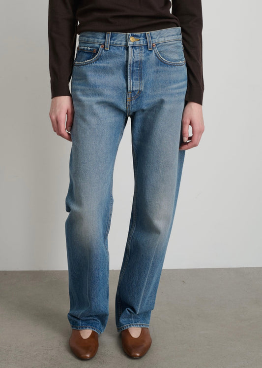Model is wearing B Sides Tilda Jeans, mid-rise draped straight indigo denim with curved inseam, tapered leg, zip fly, and brass button, part of House of Woven Stories curated collection.