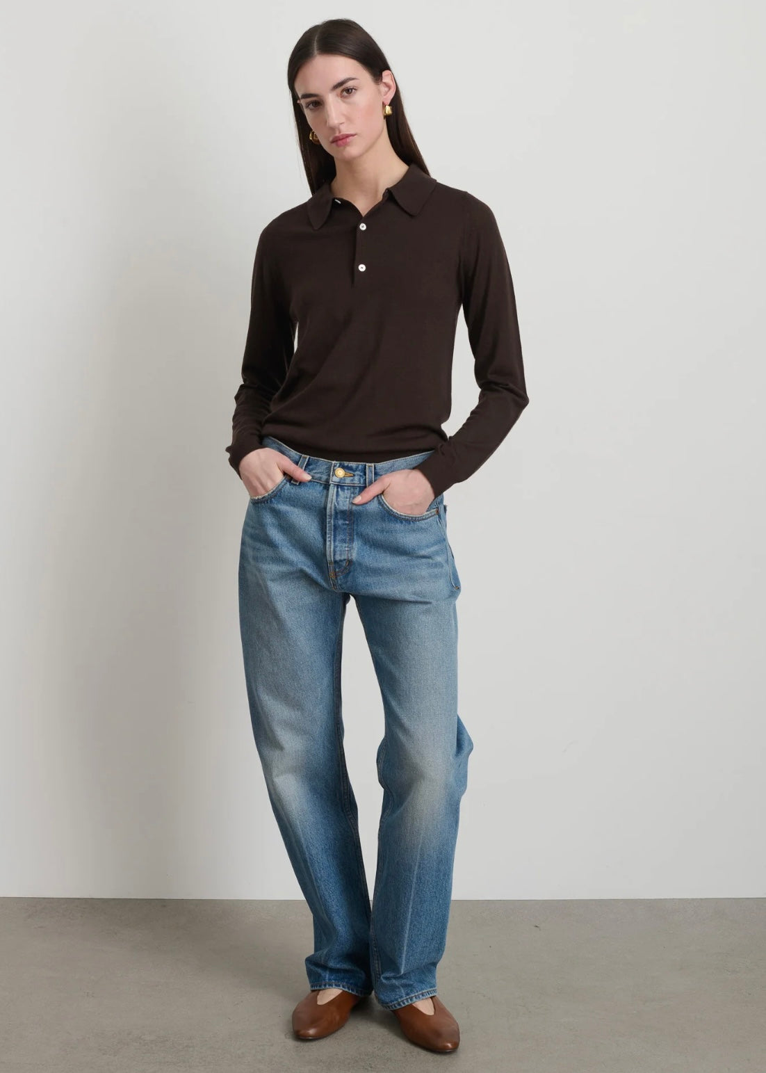 Model is wearing B Sides Tilda Jeans, mid-rise draped straight indigo denim with curved inseam, tapered leg, zip fly, and brass button, part of House of Woven Stories curated collection.