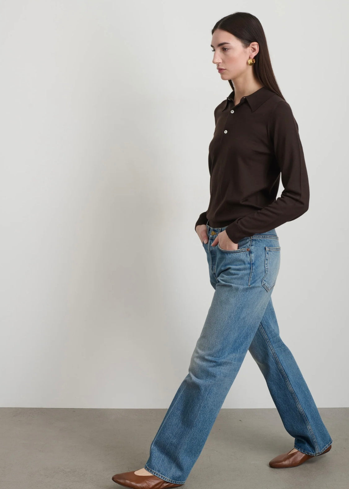 Model is wearing B Sides Tilda Jeans, mid-rise draped straight indigo denim with curved inseam, tapered leg, zip fly, and brass button, part of House of Woven Stories curated collection.