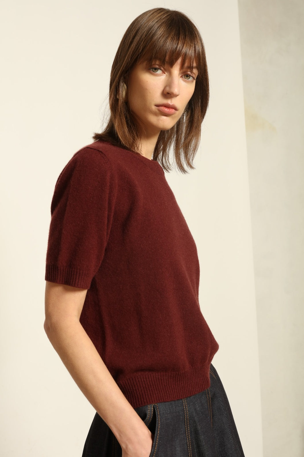 Model wearing the Burgundy Natascha Cashmere Pullover by House of Woven Stories, crafted from 100% pure Inner Mongolia cashmere, featuring a deep burgundy tone, soft breathable texture, round neckline, relaxed fit, and sustainable luxury craftsmanship