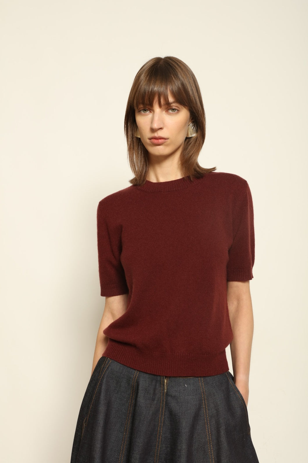 Model wearing the Burgundy Natascha Cashmere Pullover by House of Woven Stories, crafted from 100% pure Inner Mongolia cashmere, featuring a deep burgundy tone, soft breathable texture, round neckline, relaxed fit, and sustainable luxury craftsmanship