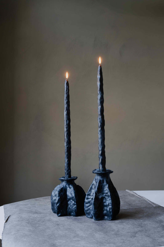 Carambola Low in Black candle holder by Oberflacht, part of the House of Woven Stories selection, handmade from beeswax and paraffin with matching twig candle and natural variations in colour and texture.