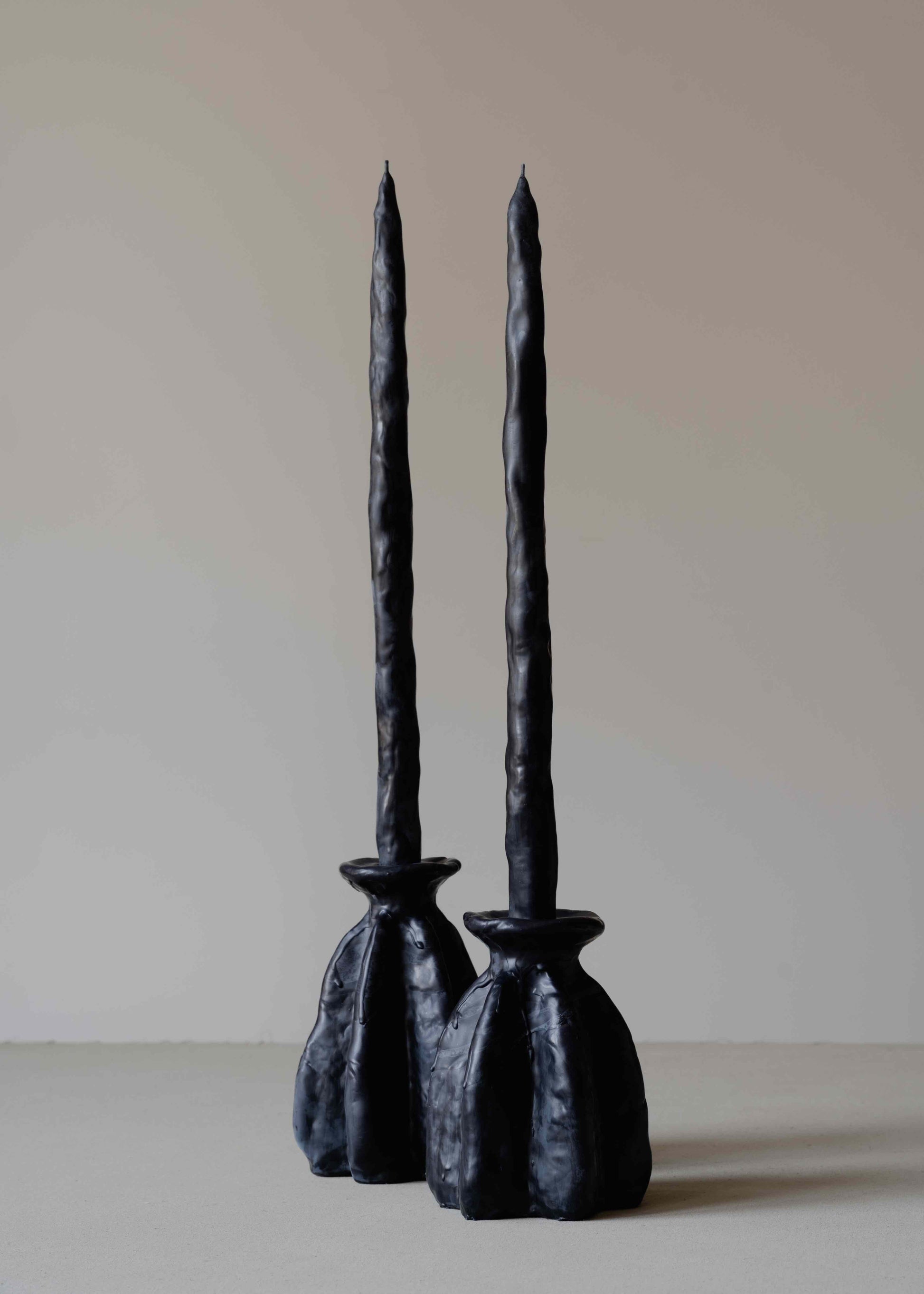 Carambola Low in Black candle holder by Oberflacht, part of the House of Woven Stories selection, handmade from beeswax and paraffin with matching twig candle and natural variations in colour and texture.