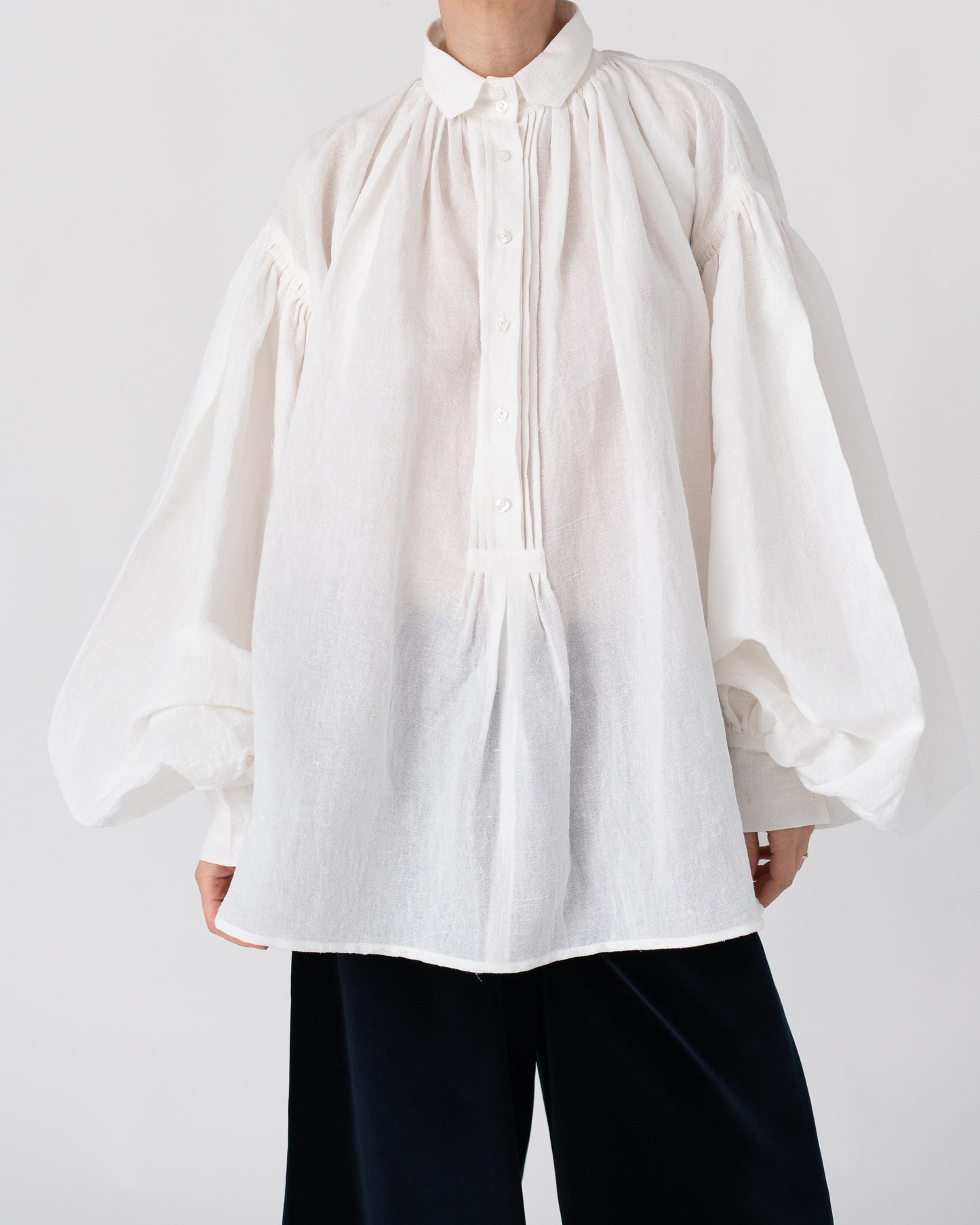 Model is wearing the Carmen Blouse by Les Vacances d’Irina, a hand-stitched linen-cotton shirt with wide sleeves and square buttons, reimagining a traditional Romanian silhouette, available at House of Woven Stories.