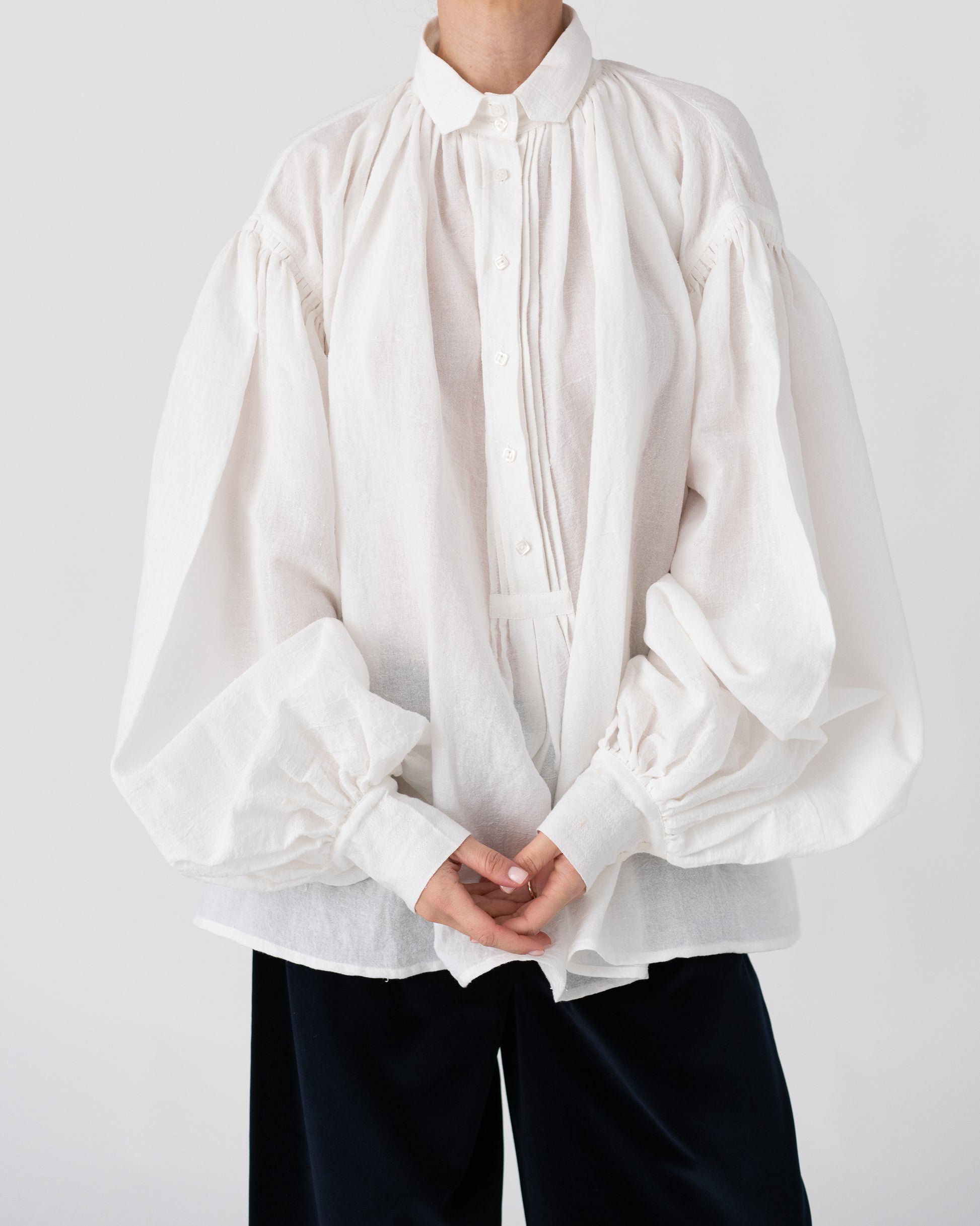 Model is wearing the Carmen Blouse by Les Vacances d’Irina, a hand-stitched linen-cotton shirt with wide sleeves and square buttons, reimagining a traditional Romanian silhouette, available at House of Woven Stories.