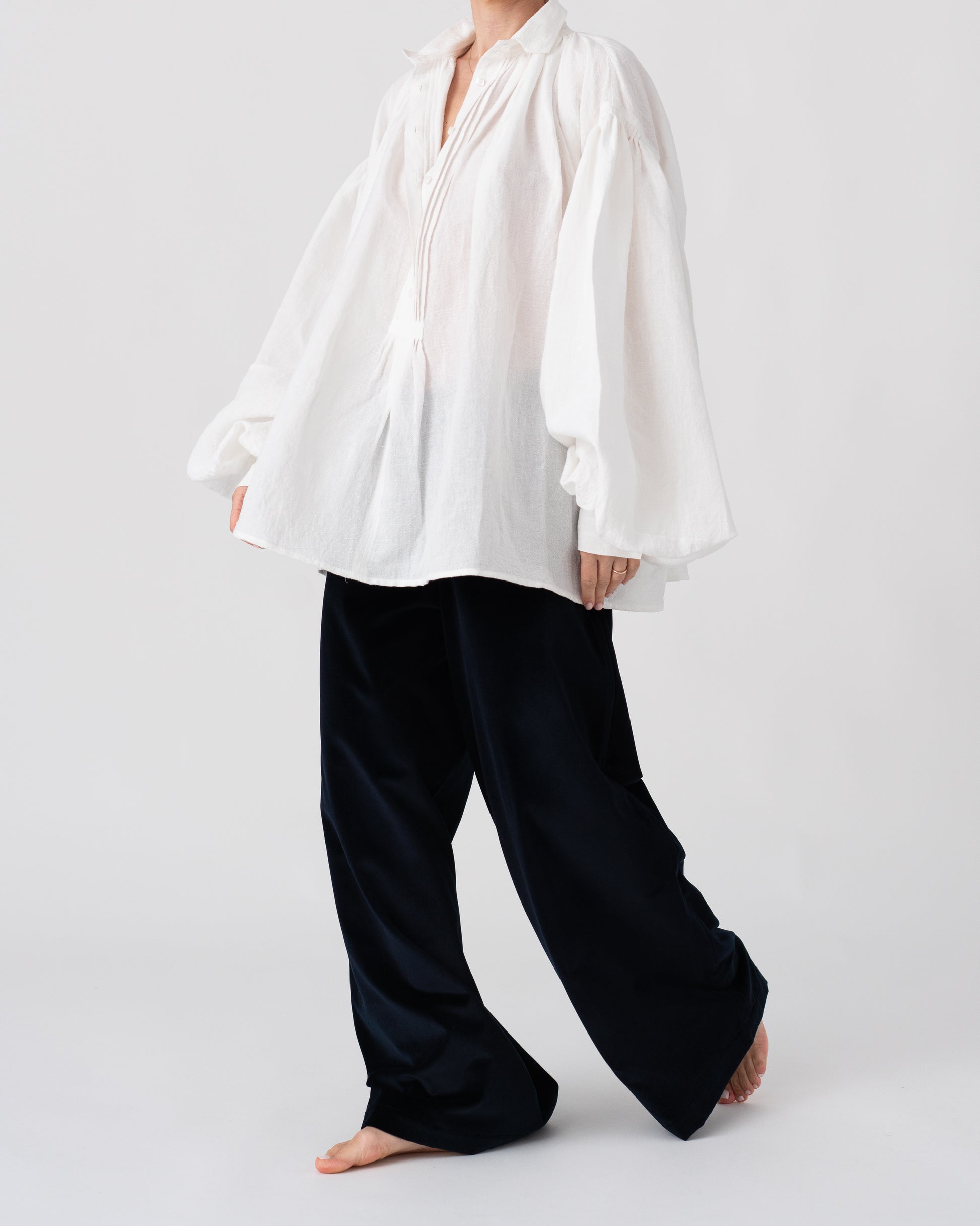 Model is wearing the Carmen Blouse by Les Vacances d’Irina, a hand-stitched linen-cotton shirt with wide sleeves and square buttons, reimagining a traditional Romanian silhouette, available at House of Woven Stories.