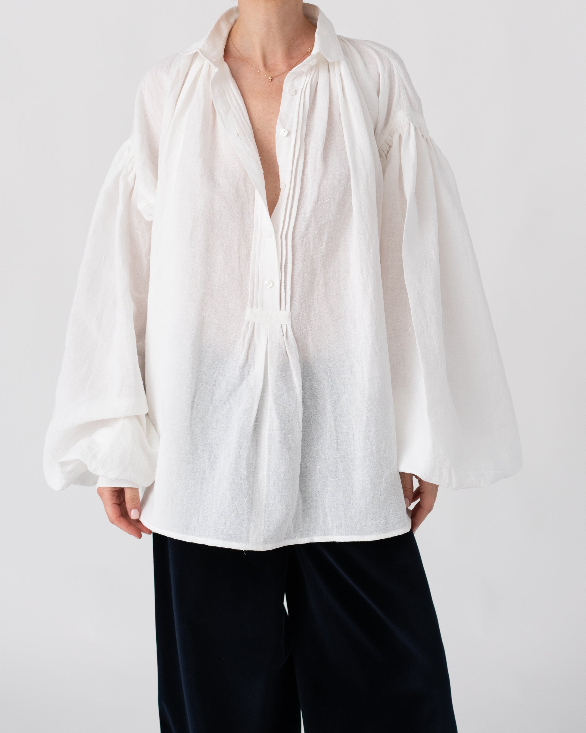 Model is wearing the Carmen Blouse by Les Vacances d’Irina, a hand-stitched linen-cotton shirt with wide sleeves and square buttons, reimagining a traditional Romanian silhouette, available at House of Woven Stories.
