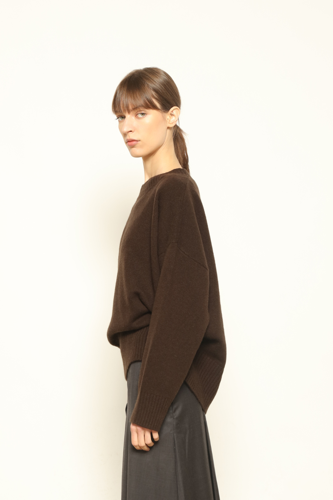 Model is wearing the chocolate Noemi Round Neck Pullover by House of Woven Stories, made from 100% pure Inner Mongolia cashmere, featuring ultra-soft, breathable, durable knitwear, relaxed fit, and timeless luxury craftsmanship