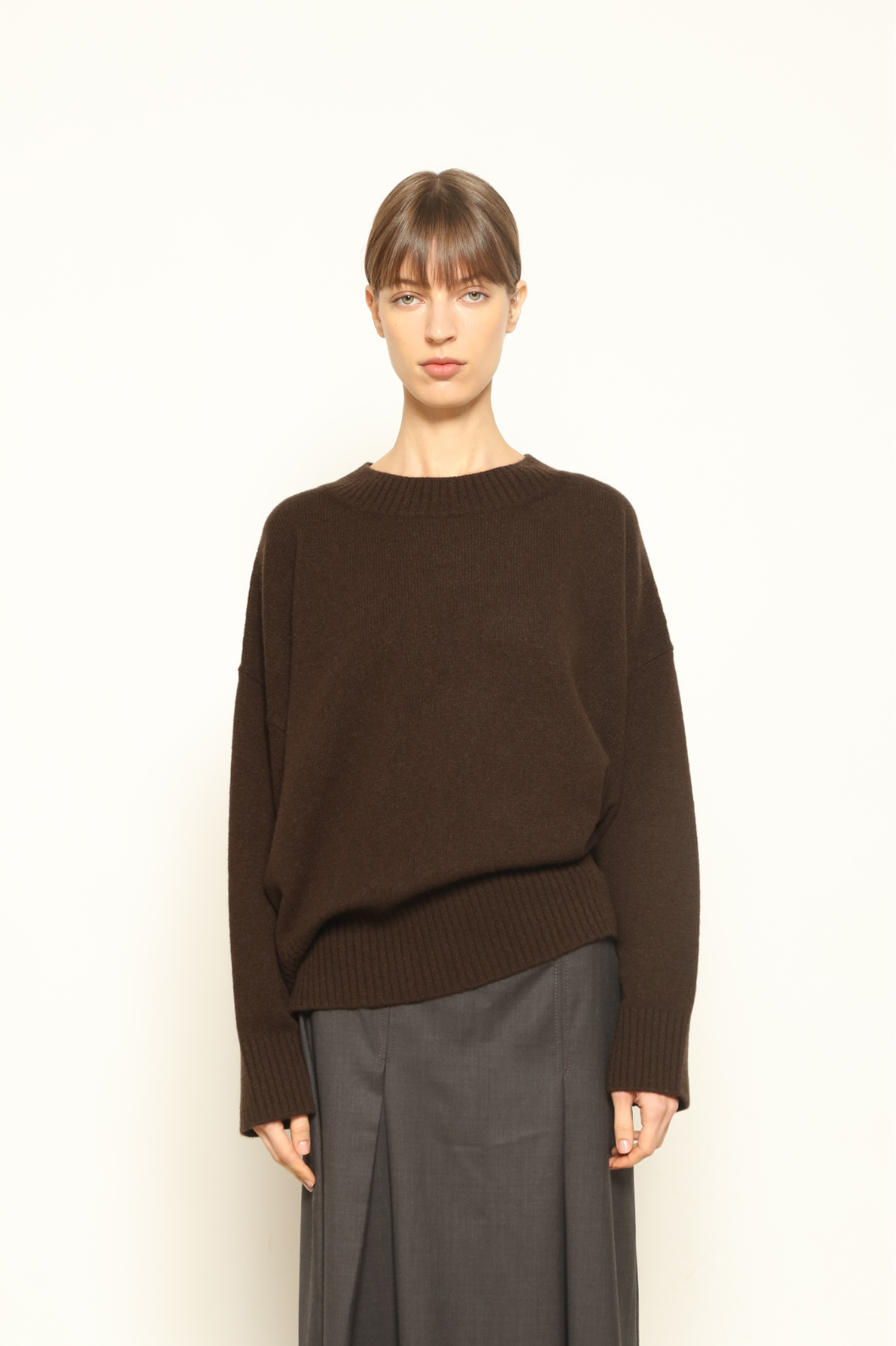 Model is wearing the chocolate Noemi Round Neck Pullover by House of Woven Stories, made from 100% pure Inner Mongolia cashmere, featuring ultra-soft, breathable, durable knitwear, relaxed fit, and timeless luxury craftsmanship