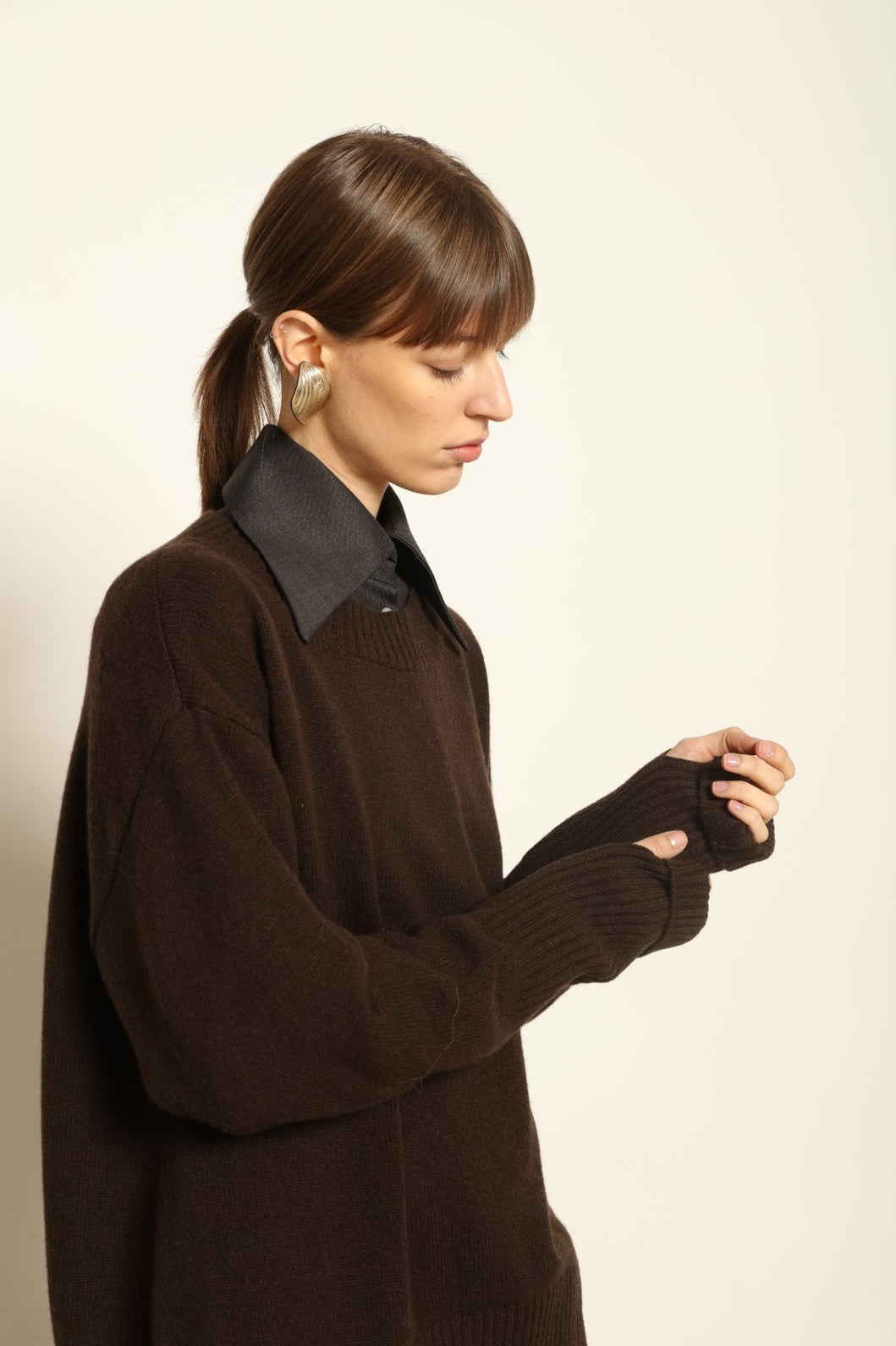 Model wearing the Chocolate Noemi Round Neck Cashmere Pullover by House of Woven Stories, made from 100% pure Inner Mongolia cashmere, featuring a deep chocolate tone, soft texture, relaxed fit, and sustainable luxury craftsmanship