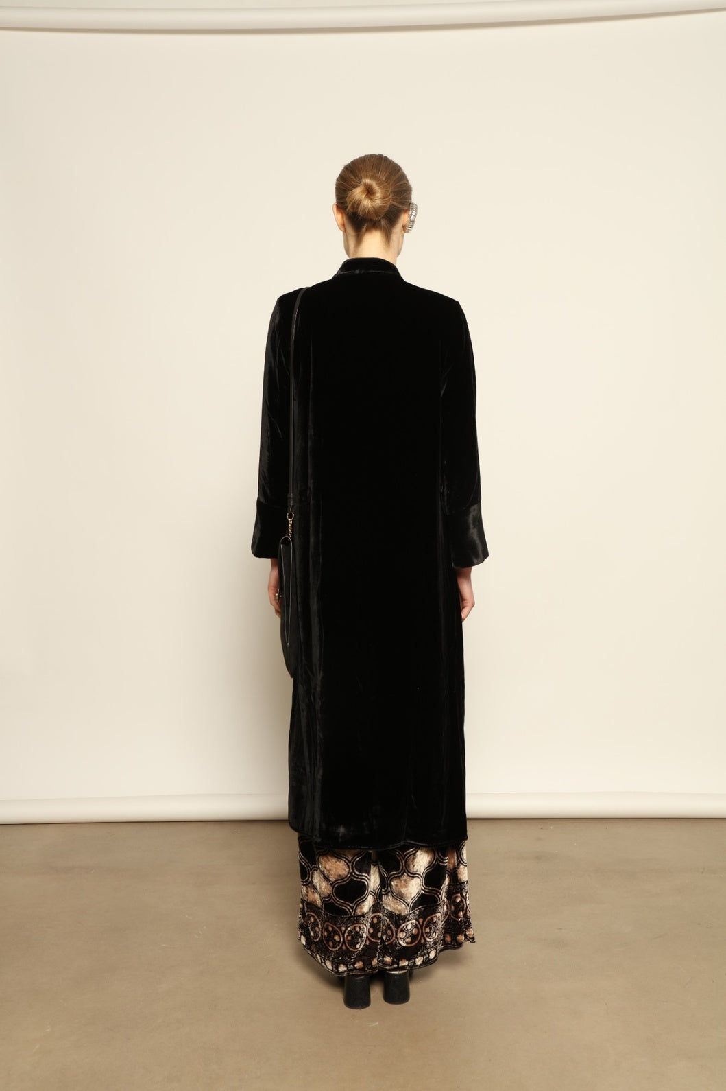 Model is wearing the Cleo Black Long Jacket VR.40 by Obidi, crafted from luxurious velvet with a structured silhouette and refined texture, combining artisanal craftsmanship with contemporary style.