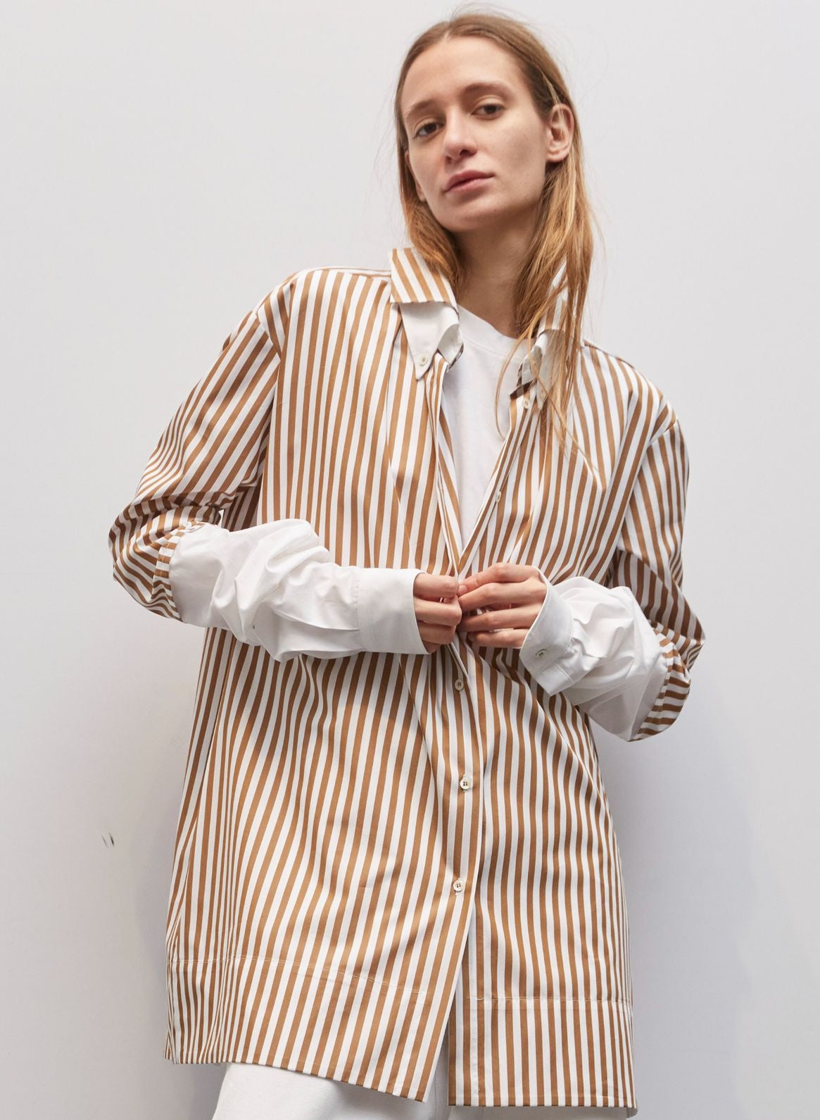 Model wearing the Crazy Cotton Shirt by Maison Jejia, featuring bold vertical stripes, crisp white cuffs, sharp collar, relaxed tailored fit, and playful yet classic design, part of the House of Woven Stories Selection