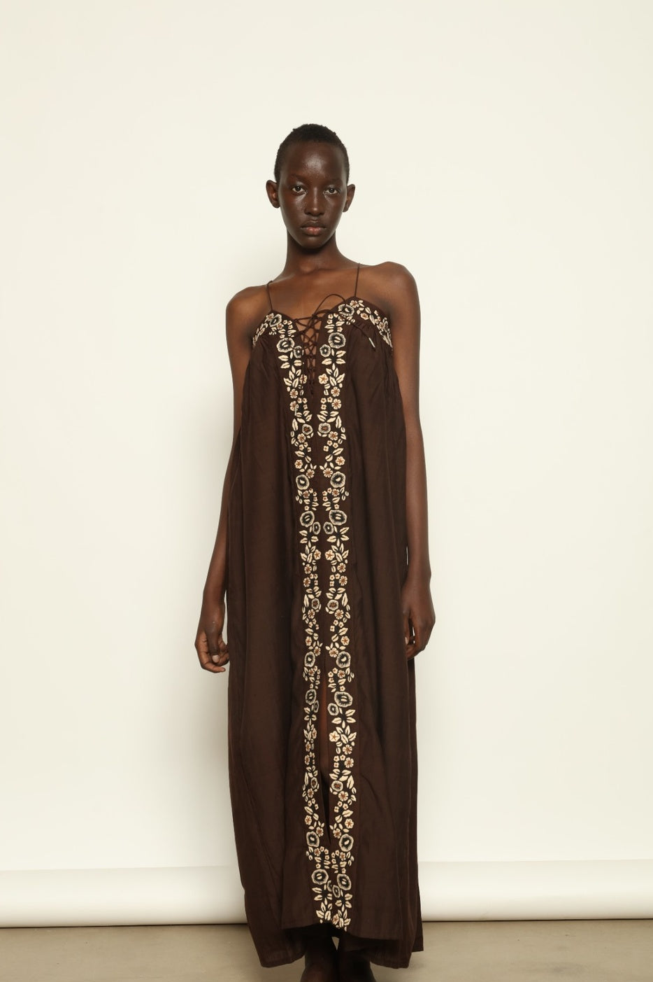 Model is wearing the Flor Brown Linen Dress by Supernaturae x HONS, crafted in heavyweight sustainable linen with a wrap-tie silhouette, earthy brown plant-dyed finish and structured yet breathable form. Made in collaboration with artisan communities in Kutch, Gujarat, this ethical resortwear piece features organic tonal variations and timeless design
