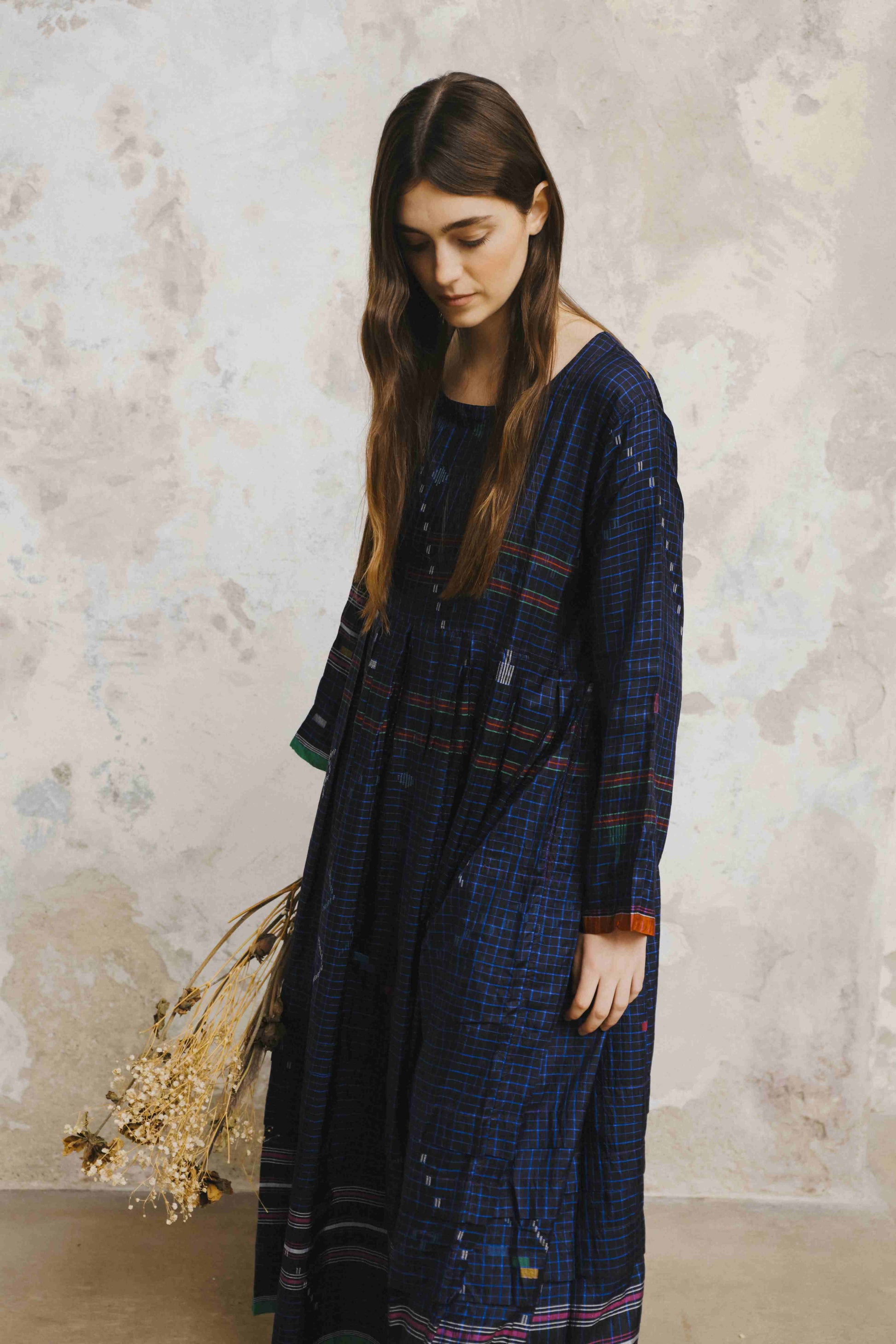 Model is wearing the Folklore 13 handmade silk dress by Injiri, featuring an empire waist, enamel buttons, and ribboned sleeves, artisan-made in India.