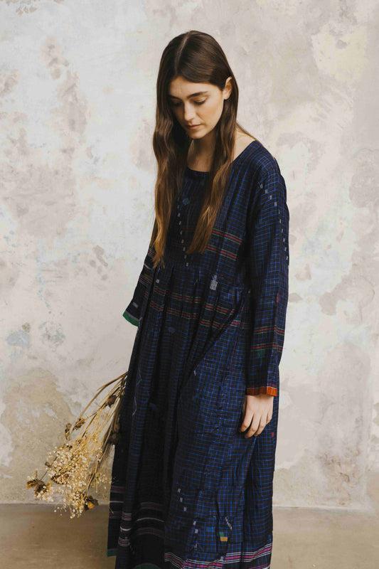 Model is wearing the Folklore 13 handmade silk dress by Injiri, featuring an empire waist, enamel buttons, and ribboned sleeves, artisan-made in India.