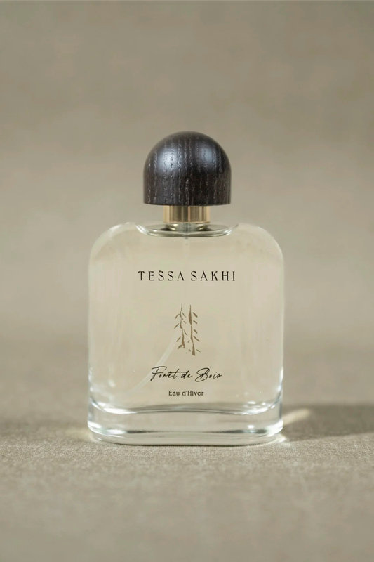 Bottle of Forêt de bois – Eau d’Hiver by Tessa Sakhi, a unisex woody and spicy Eau de Parfum with notes of juniper, cedar, tobacco, and ambergris. A sophisticated and mysterious fragrance curated by House of Nomad Stories.