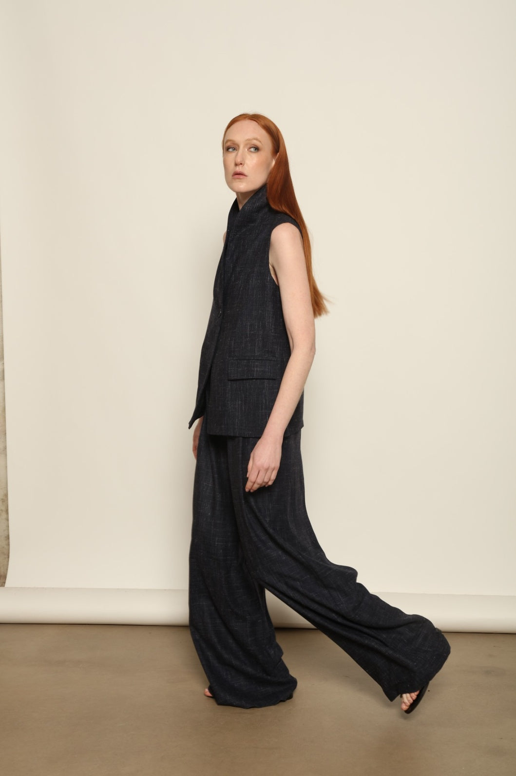 Model is wearing the Franca night blue and white gilet from the House of Woven Stories selection, a women’s tailored waistcoat made in Italy in Piedmont with a softly structured silhouette, designed for fluid layering and ethical contemporary fashion.