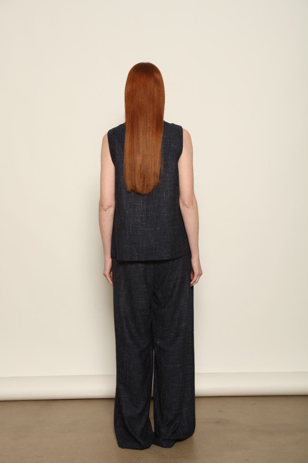 Model is wearing the Franca night blue and white gilet from the House of Woven Stories selection, a women’s tailored waistcoat made in Italy in Piedmont with a softly structured silhouette, designed for fluid layering and ethical contemporary fashion.