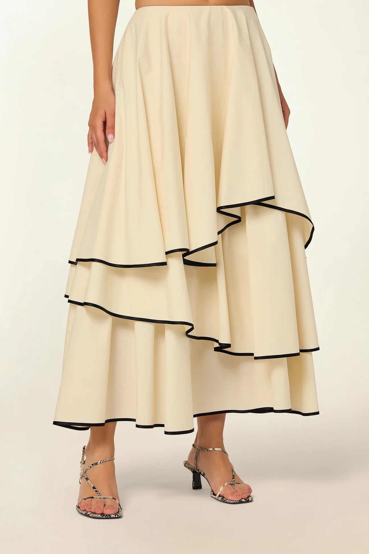 Model wearing a Frill Layer Skirt by Abadia from the House of Nomad Stories collection, featuring layered frill detailing, soft volume, and a flowing cotton blend silhouette with elegant movement.