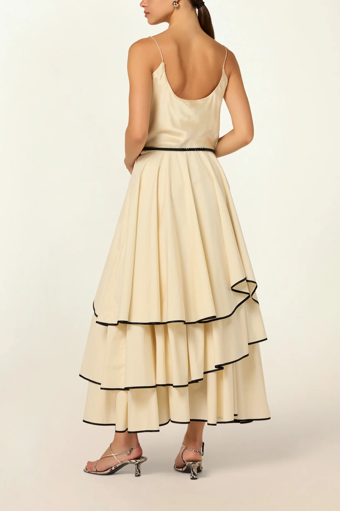 Model wearing a Frill Layer Skirt by Abadia from the House of Nomad Stories collection, featuring layered frill detailing, soft volume, and a flowing cotton blend silhouette with elegant movement.