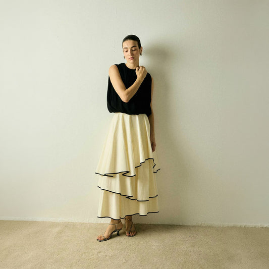 Model wearing a Frill Layer Skirt by Abadia from the House of Nomad Stories collection, featuring layered frill detailing, soft volume, and a flowing cotton blend silhouette with elegant movement.