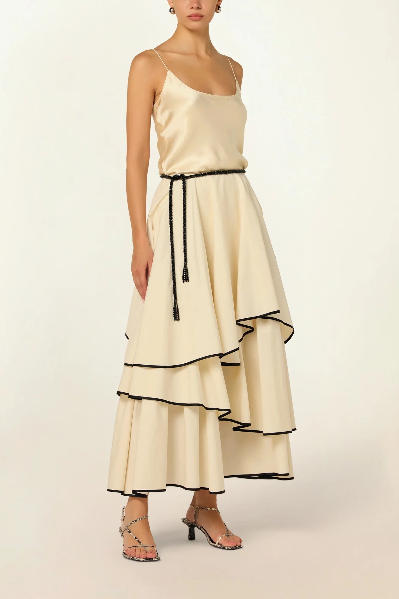 Model wearing a Frill Layer Skirt by Abadia from the House of Nomad Stories collection, featuring layered frill detailing, soft volume, and a flowing cotton blend silhouette with elegant movement.