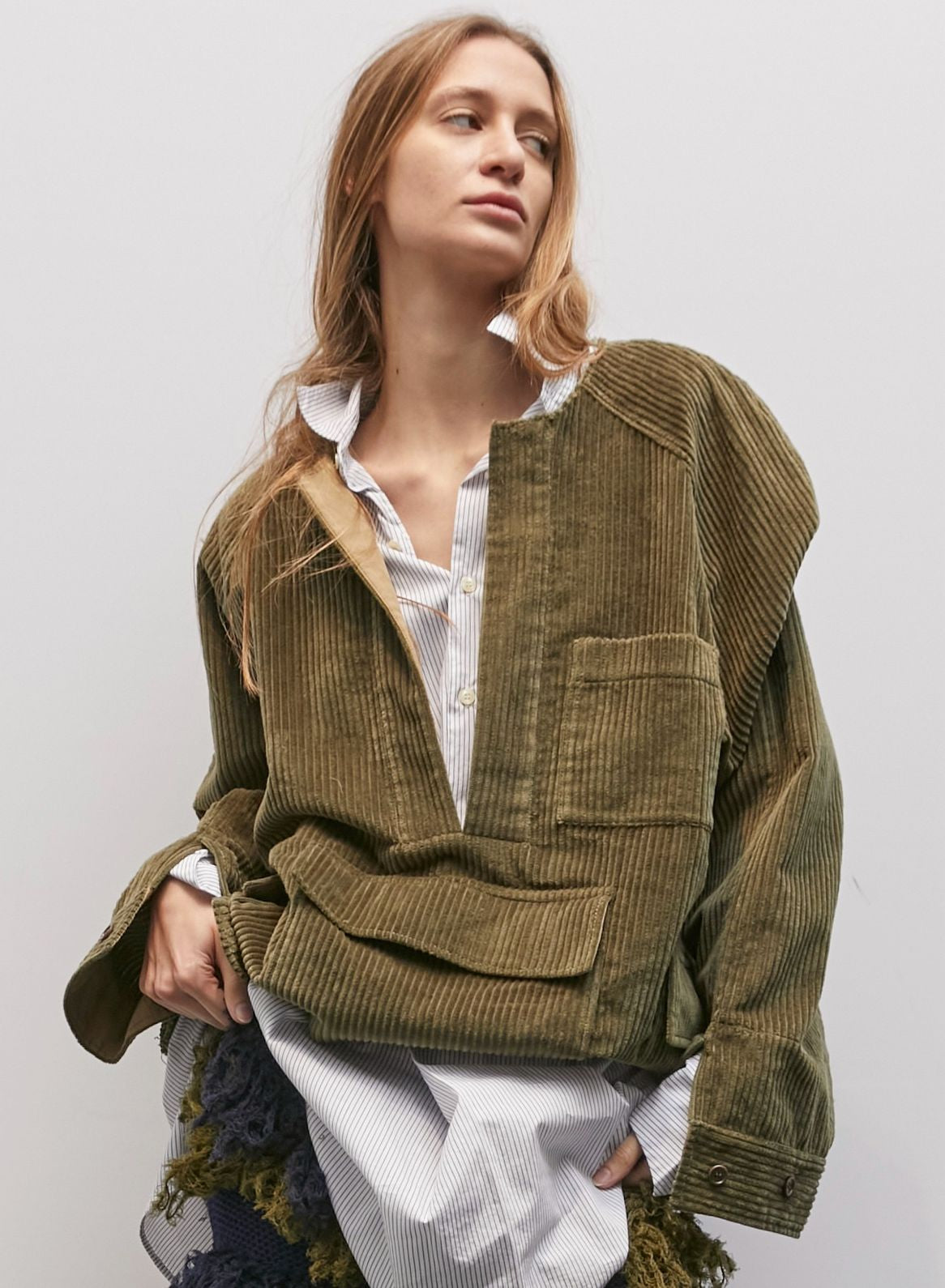 Model wearing the Giulio Military Green Velvet Shirt by Maison Jejia, part of the House of Woven Stories selection, featuring plush ribbed velvet, relaxed silhouette, large utility pockets, and deep military green tone