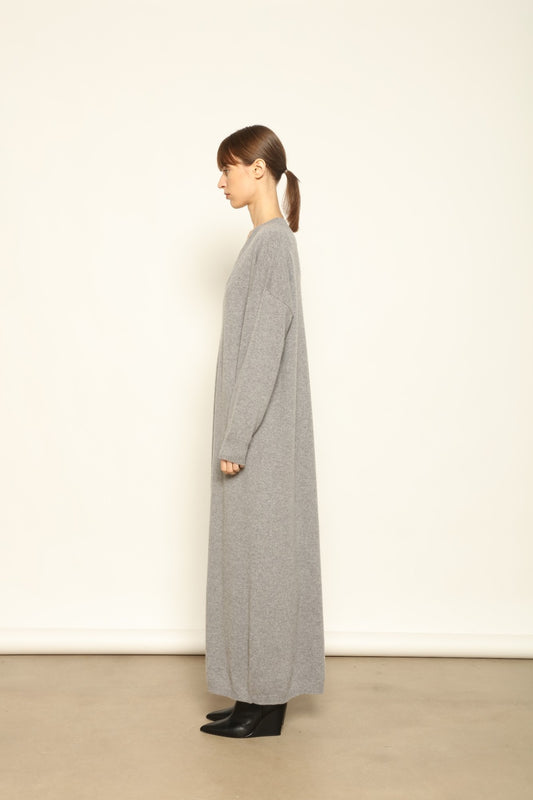 Model is wearing the Graphite Katharina V-Neck Cashmere Maxi Dress by House of Woven Stories, made from 100% pure Inner Mongolia cashmere, featuring a soft, breathable, warm knit with a long flowing silhouette, deep V-neckline, and timeless ethical luxury craftsmanship