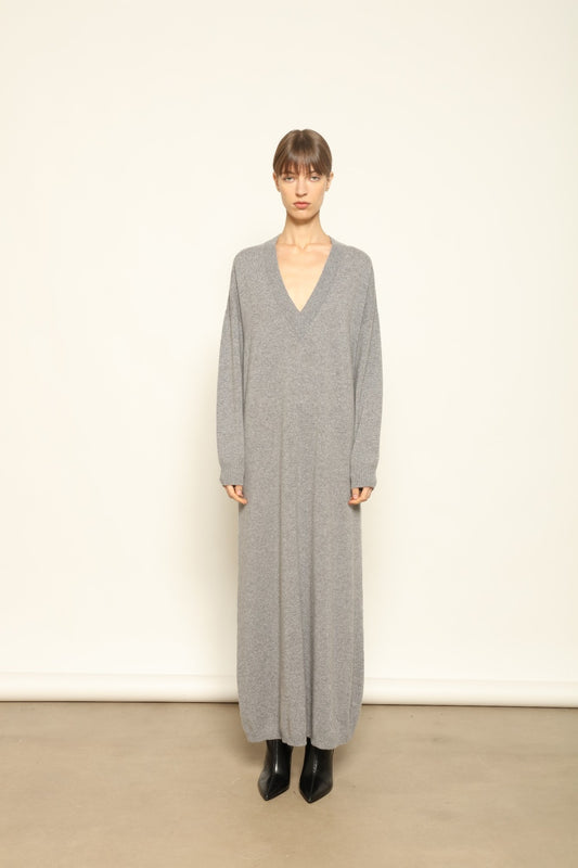 Model is wearing the Graphite Katharina V-Neck Cashmere Maxi Dress by House of Woven Stories, made from 100% pure Inner Mongolia cashmere, featuring a soft, breathable, warm knit with a long flowing silhouette, deep V-neckline, and timeless ethical luxury craftsmanship