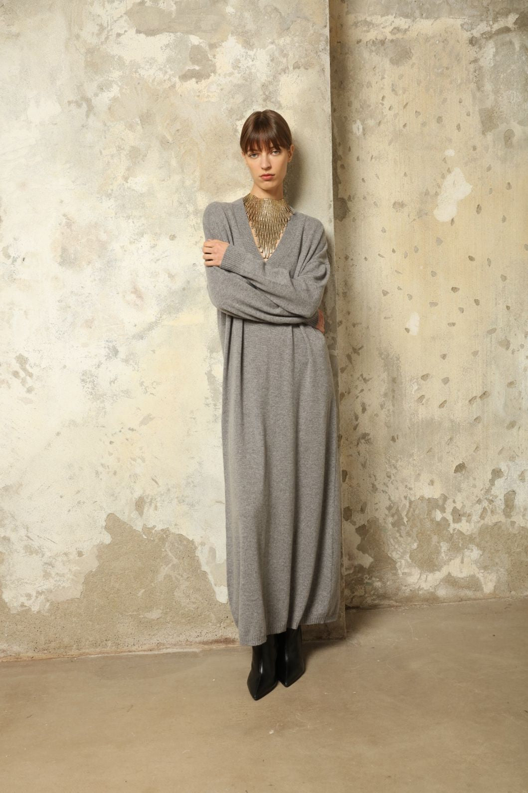 Model is wearing the Graphite Katharina V-Neck Cashmere Maxi Dress by House of Woven Stories, made from 100% pure Inner Mongolia cashmere, featuring a soft, breathable, warm knit with a long flowing silhouette, deep V-neckline, and timeless ethical luxury craftsmanship