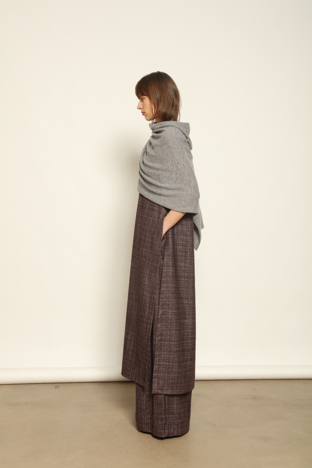 Model wearing the Graphite Leni Cashmere Scarf by House of Woven Stories, made from 100% pure Inner Mongolia cashmere, featuring a soft graphite color, lightweight drape, smooth texture, lasting warmth, and sustainable luxury craftsmanship