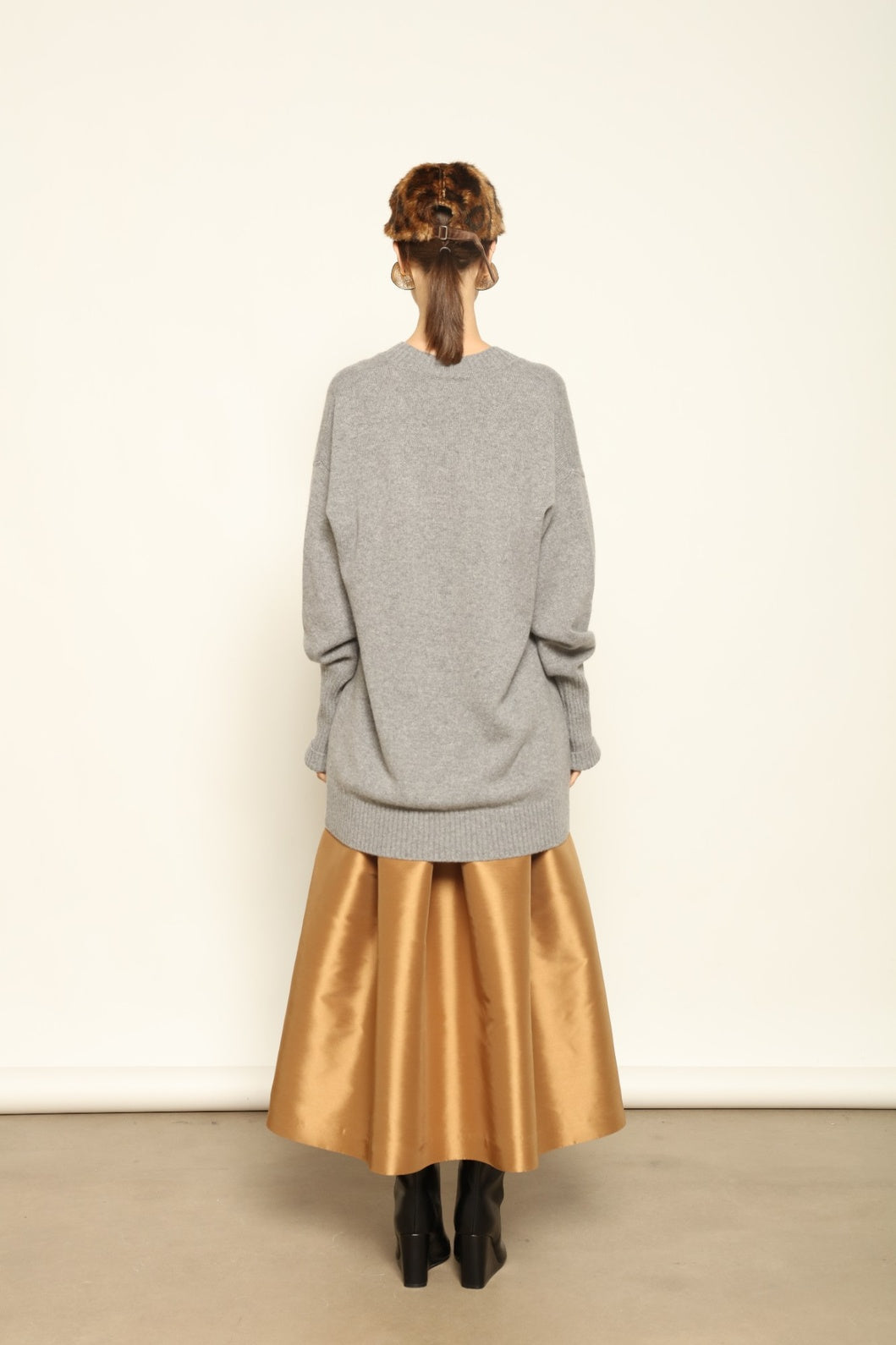 Model wearing the Graphite Nina V-Neck Long Sweater by House of Woven Stories, crafted in Italy from 100% pure Inner Mongolia cashmere, featuring a deep graphite hue, elongated silhouette, soft drape, and timeless sustainable knitwear design