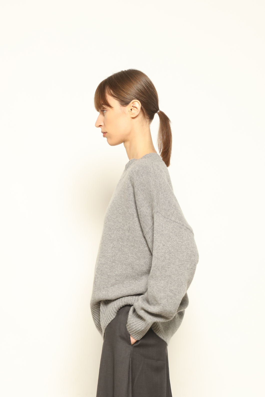 Model is wearing the graphite Noemi Round Neck Pullover by House of Woven Stories, crafted from 100% pure Inner Mongolia cashmere, featuring ultra-soft, breathable, durable knitwear, relaxed fit, round neckline, and timeless ethical luxury design