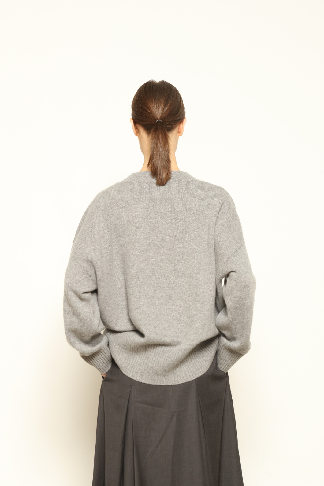 Model is wearing the graphite Noemi Round Neck Pullover by House of Woven Stories, crafted from 100% pure Inner Mongolia cashmere, featuring ultra-soft, breathable, durable knitwear, relaxed fit, round neckline, and timeless ethical luxury design