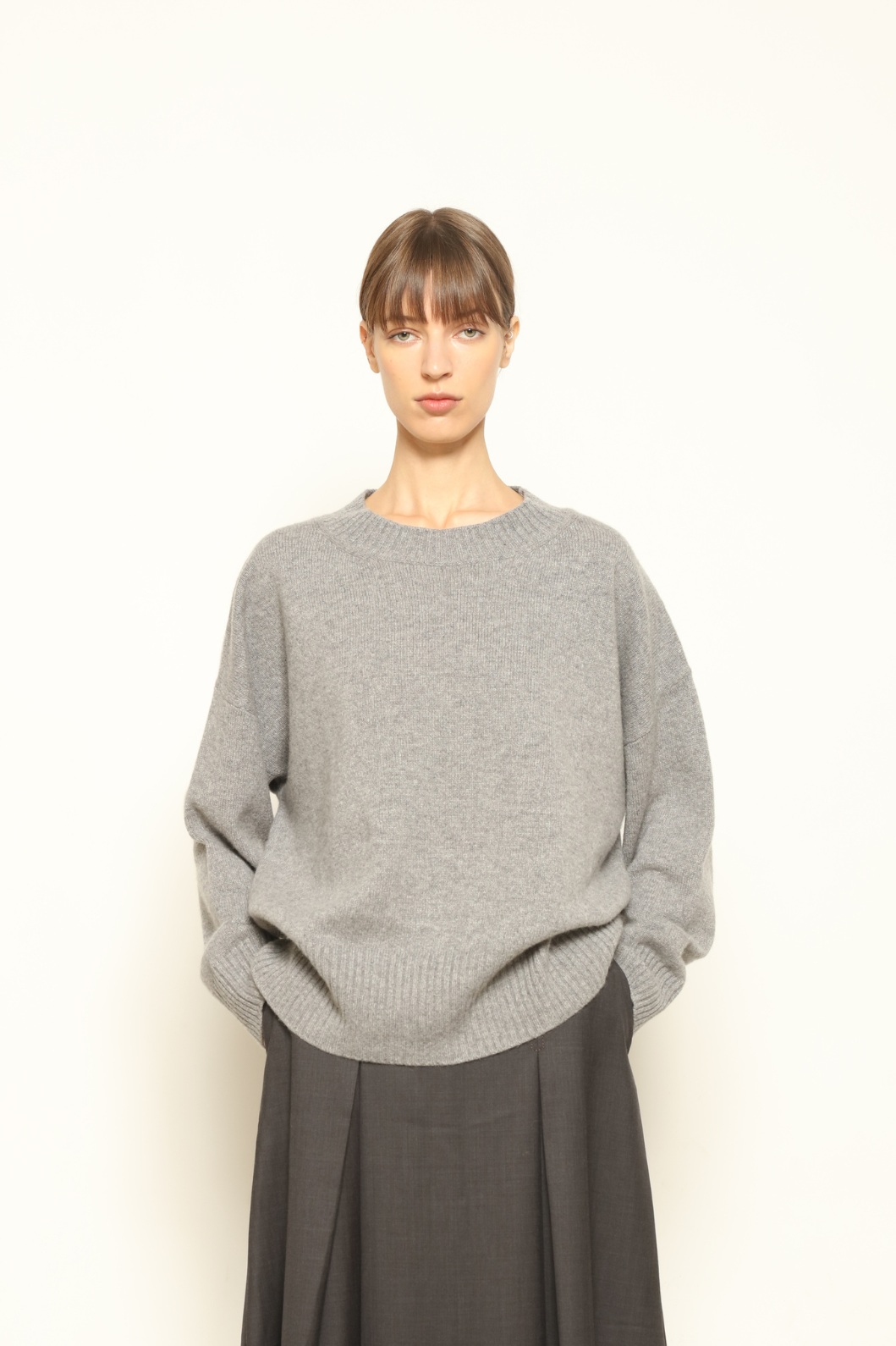 Model is wearing the graphite Noemi Round Neck Pullover by House of Woven Stories, crafted from 100% pure Inner Mongolia cashmere, featuring ultra-soft, breathable, durable knitwear, relaxed fit, round neckline, and timeless ethical luxury design