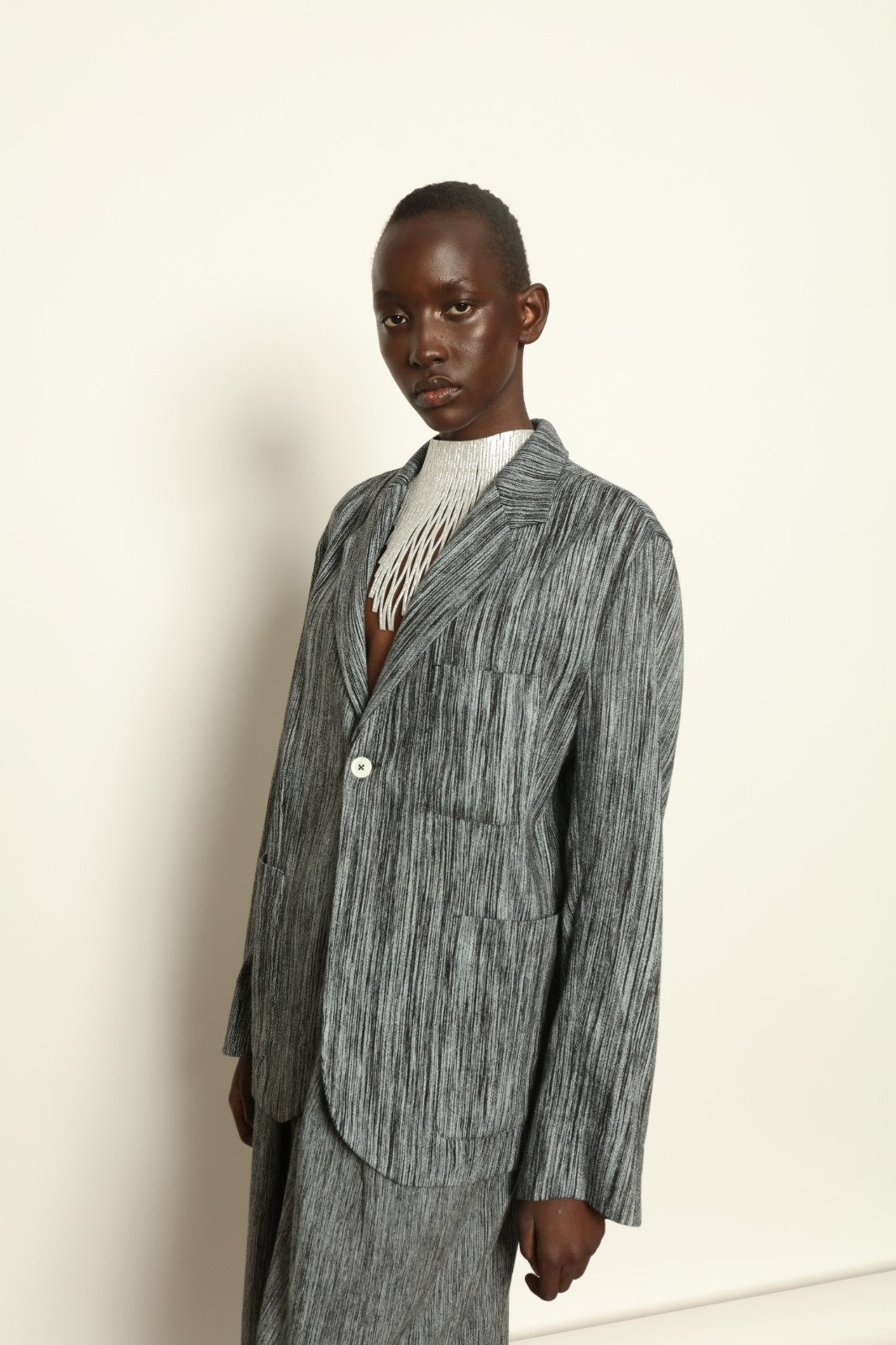 Model is wearing the Grey Chambray Blazer by Marrakshi Life, part of House of Nomad Stories collection, handwoven cotton blazer with relaxed fit, notched collar, and classic tailored details
