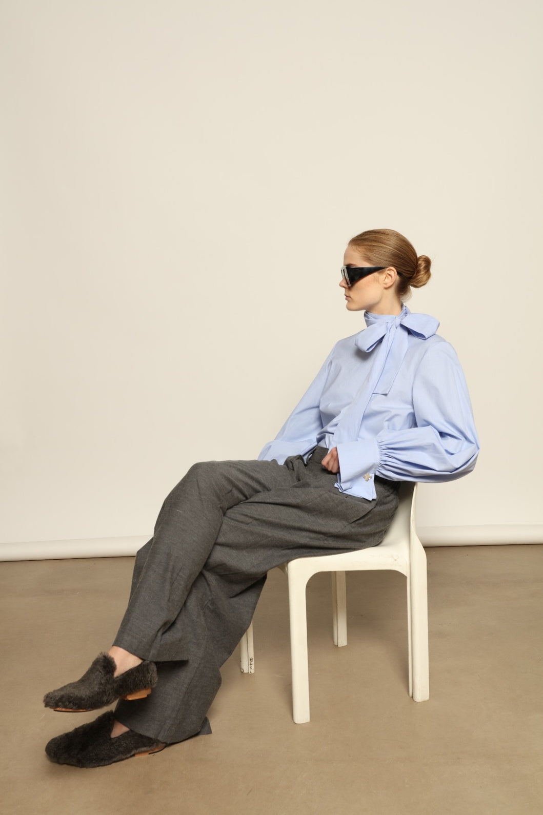 Model is wearing Grey Melange Parigi Wool Trousers by House of Woven Stories, part of the curated House of Woven Stories selection, crafted in Italy from soft cotton flannel with mid-rise waist, front pleats, and wide-leg silhouette for refined comfort.