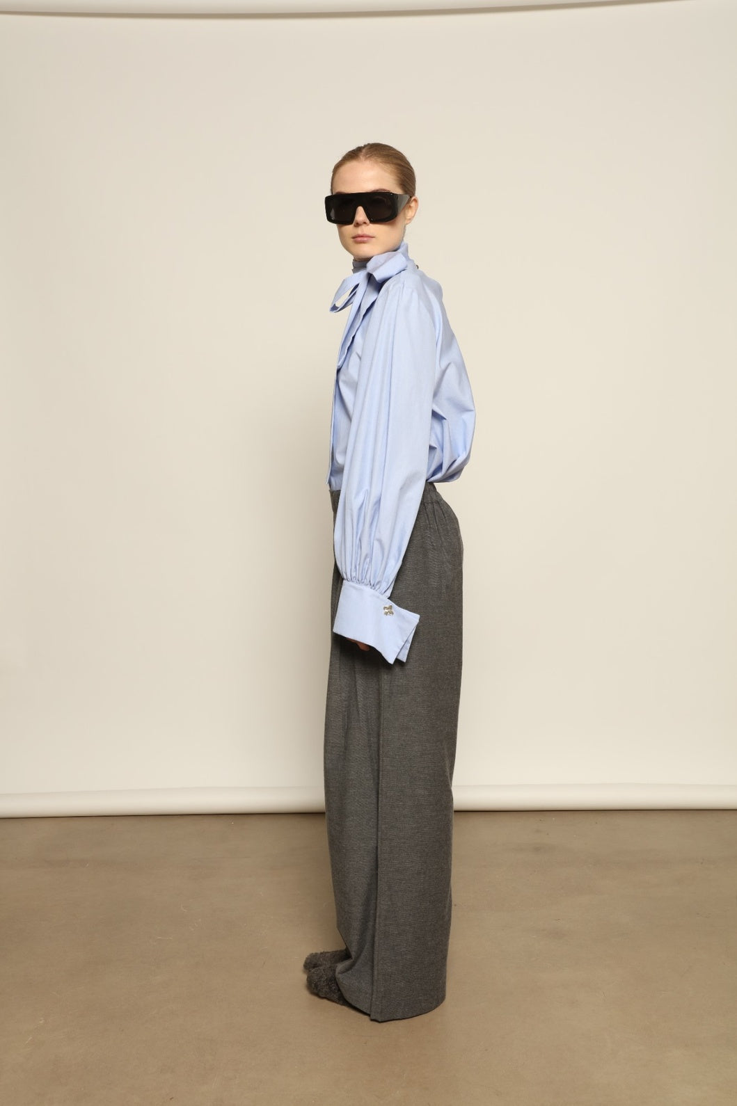 Model is wearing Grey Melange Parigi Wool Trousers by House of Woven Stories, part of the curated House of Woven Stories selection, crafted in Italy from soft cotton flannel with mid-rise waist, front pleats, and wide-leg silhouette for refined comfort.
