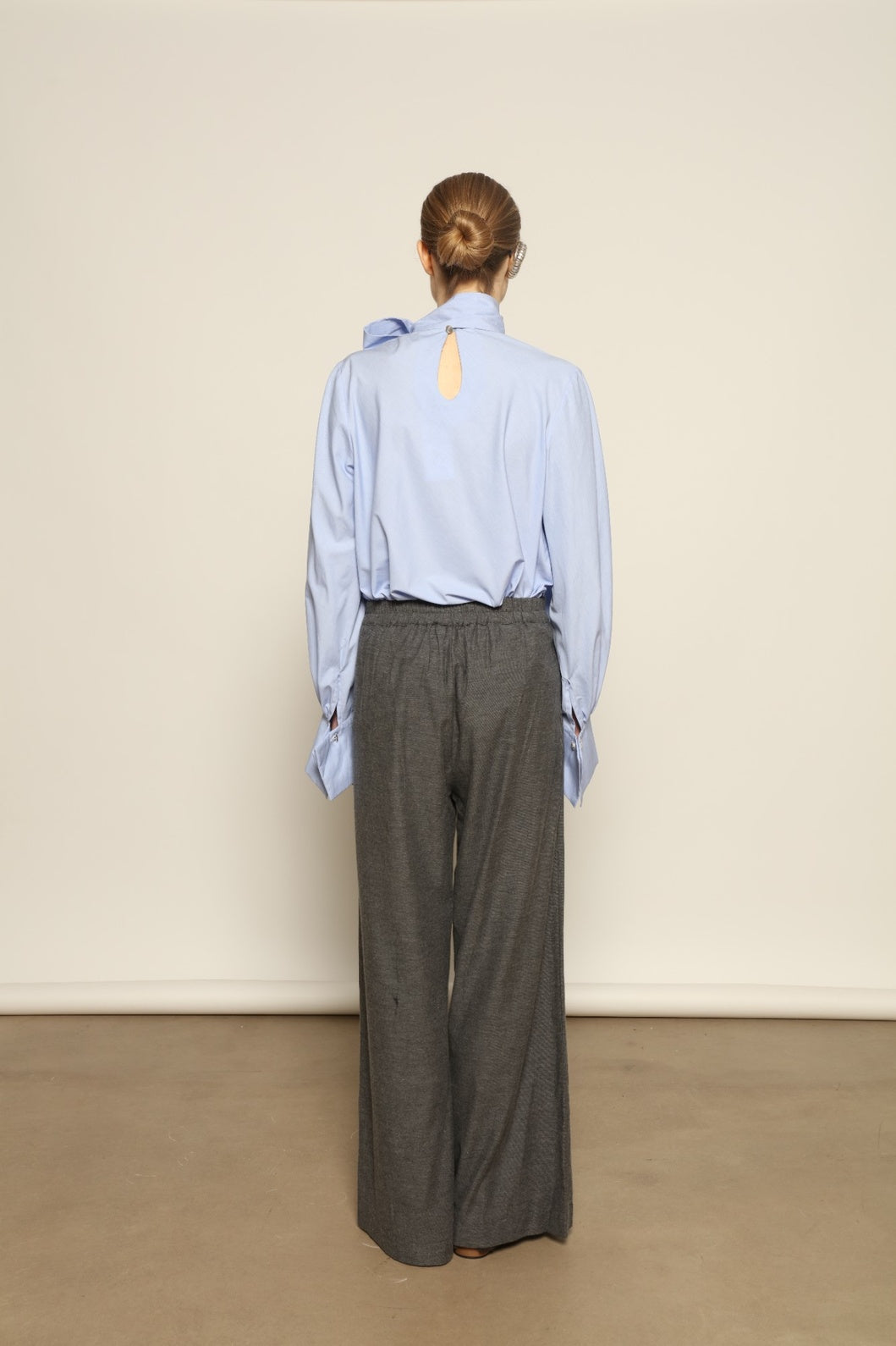 Model is wearing Grey Melange Parigi Wool Trousers by House of Woven Stories, part of the curated House of Woven Stories selection, crafted in Italy from soft cotton flannel with mid-rise waist, front pleats, and wide-leg silhouette for refined comfort.