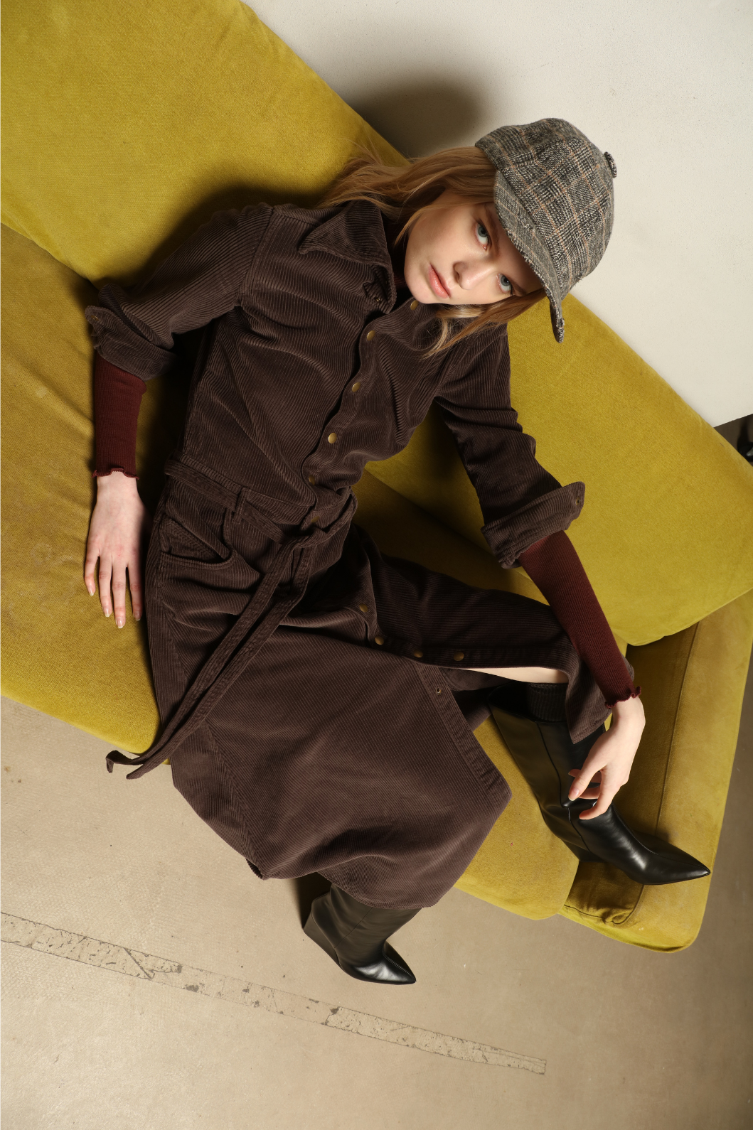 Model is wearing La Robe Trompe L’Oeil in Chocolate by Happy Haus, a corduroy cotton trompe-l’œil dress with removable belt, tulip-shaped pockets and brass snaps, curated in the House of Woven Stories selection.